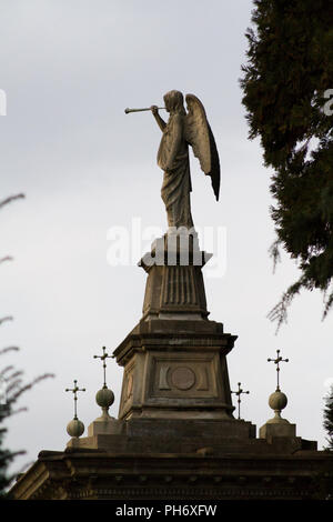 Milano, Italia. 2018/2/8. Una statua di un angelo di suonare la tromba sulla parte superiore di una tomba al Cimitero Monumentale ('Monumental' cimitero) a Milano. Foto Stock