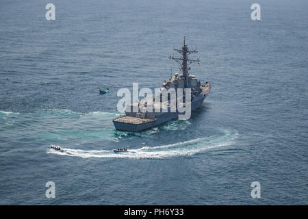 180828-N-UX013-1874 Golfo di Aden (Agosto 28, 2018) una visita, scheda, ricerca e sequestro team dall'guidato-missile destroyer USS Jason Dunham (DDG 109) approccio un skiff durante le operazioni di sicurezza marittima. La skiff stateless è stato trovato che trasportano una spedizione di oltre mille traffico illecito di armi. Dunham è distribuito negli Stati Uniti Quinta Flotta area di operazioni a sostegno di operazioni navali per garantire stabilità marittimo e la sicurezza nella regione centrale di collegamento del Mediterraneo e del Pacifico attraverso l'Oceano Indiano occidentale e tre strategici punti di strozzatura. (U.S. Navy foto di comunicazione di massa Speciali Foto Stock