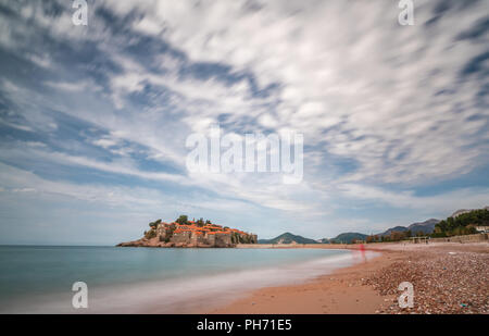 Sveti Stefan, Montenegro - Aprile 2018 : spiaggia di fronte alla storica città vecchia, attualmente di proprietà privata e si è trasformato in un lusso costoso hote Foto Stock