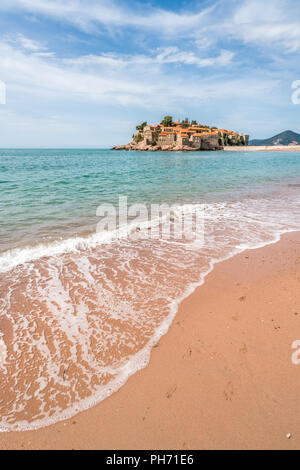 Sveti Stefan, Montenegro - Aprile 2018 : spiaggia di fronte alla storica città vecchia, attualmente di proprietà privata e si è trasformato in un lusso costoso hote Foto Stock