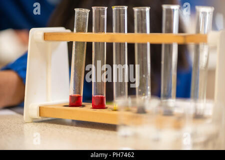 Colorati tubi di prova fotografato in un aula scolastica durante una lezione di scienze e di esperimento. Foto Stock