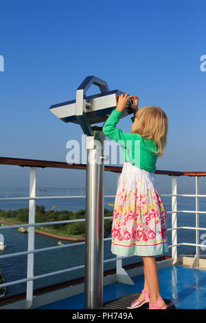 Bionda ragazza che guarda attraverso il telescopio vicino a Venezia Foto Stock