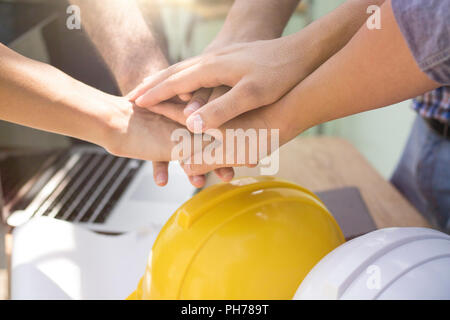 Concetto di lavoro di squadra di ingegneri e lavoratore mettere mano su insieme sul tavolo di lavoro per lavoro potente. Foto Stock