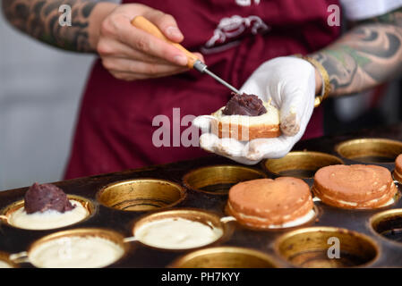 Londra, Regno Unito. Il 31 agosto 2018. Un cuoco rende wheelcakes nella giornata di apertura della tre giorni di cibo Cinese Festival a Potters Fields Park vicino al Municipio. Così come il cibo e le bevande da differenti parti della Cina preparate di fresco per i visitatori di provare, ci sono dimostrazioni di cottura e presentazioni da parte del Regno Unito Cultura Han Associazione. Credito: Stephen Chung / Alamy Live News Foto Stock