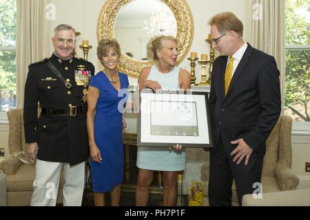 Assistente Comandante del Marine Corps gen. Glenn M. Walters, a sinistra e a sua moglie, Gail A. Walters, centro a destra, aprire un dono dalla onorevole Thomas B. Modly, destra, sotto segretario della Marina Militare, e sua moglie, Robyn Modly, centro a sinistra, durante un ricevimento prima di una serata parade presso la Casa del Commandants, caserma marini Washington, Washington D.C., 29 giugno 2018. La sfilata serale estate tradizione iniziò nel 1934 e dispone il trapano silenzioso plotone, U.S. Banda di Marino, Stati Uniti Tamburo di marino e Bugle Corps e due società marching. Più di 3.500 ospiti sfilerà ogni w Foto Stock