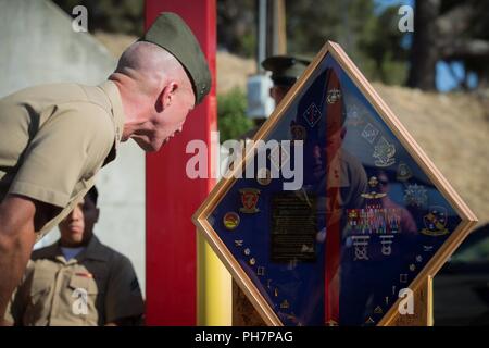 Stati Uniti Marine Corps Il Mag. Gen. Eric M. Smith, il comandante generale della prima divisione Marine (MARDIV), legge una lapide dato come un dono durante una cerimonia di pensionamento per Col. Christopher S. Dowling, capo del personale del 1° MARDIV, in Marine Corps base Camp Pendleton, California, 29 giugno 2018. La cerimonia si è svolta in onore di Dowling è 34 anni di servizio meritorio. Foto Stock