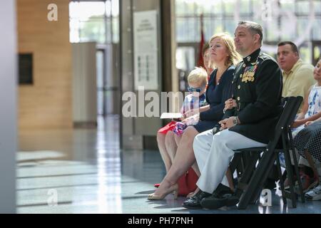 Stati Uniti Marine Corps Lt. Col. Guy G. Berry, AV-8B capo pilota, sede Marine Corps, terra la sua famiglia ascoltare durante la sua pensione cerimonia presso il Museo Nazionale del Marine Corps, Triangolo, Va., 29 giugno 2018. Berry servita 22 onorevoli anni nelle Marine Corps. Foto Stock