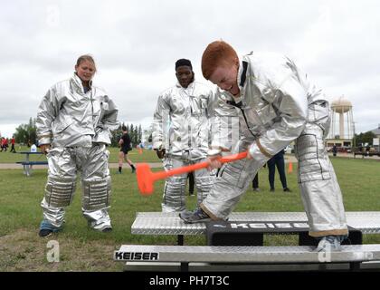 Team Minot aviatori competere in un incendio muster sfida durante la quarta stagione estiva con giochi a Minot Air Force Base in North Dakota, 29 giugno 2018. La sfida inclusi incendio indossando indumenti di protezione, trascina il corpo, un camion dei pompieri tirare e lo pneumatico. Foto Stock