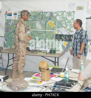 Lt. Col. Anis Lamouchi (sinistra) dell'esercito tunisino ricorda un luogo su una mappa durante una missione breve al posto di comando come Sgt. Ouali Karim si traduce per lui Giugno 25 durante la rotazione 18-08. Foto Stock