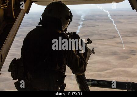 IRAQ (18 giugno 2018) UN U.S. Marine capo equipaggio osserva razzi e incendi di prova un M240D medie mitragliatrice da una MV-22B Osprey durante una missione di rialimentazione sopra l'Iraq, 18 giugno 2018. CJTF-funzione OIR è il braccio militare della coalizione globale per sconfiggere ISIS in determinate parti dell'Iraq e la Siria. Foto Stock