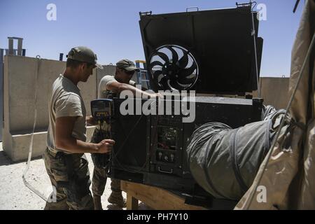 Stati Uniti Air Force aviatori assegnati alla 727th Expeditionary Air Control Squadron (EACS) impostare un gruppo di climatizzazione per tende in corrispondenza della loro zona di funzionamento a una coalizione airfield nel nordest della Siria, 29 giugno 2018. Il 727th EACS, noto come 'il perno del fuso a snodo", fornisce aria di comando e le capacità di controllo di aria comune le operazioni negli Stati Uniti Forze aeree centrali di comando area di responsabilità. Foto Stock