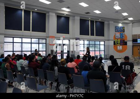 Texas A&M University Programma Colonias Basso Rio Grande direttore regionale, Laura Trevino, accoglie i residenti locali in attesa di servizi medici a Betty Harwell Middle School di Edinburg, Texas. Circa 50 Stati Uniti Esercito di soldati di riserva assegnata al medico 7235th Unità di supporto fuori di Orlando, Texas, ha lavorato in partnership con Texas A&M programma Colonias Giugno 16-27 per fornire cure mediche di Hidalgo County's meno servite la popolazione di colonia. I servizi forniti da personale militare sono eseguite tramite il Dipartimento della difesa innovativi della disponibilità di formazione, una civile-militare che programma bu Foto Stock