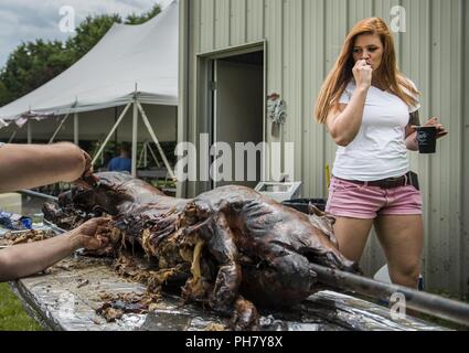 Brooke Grether, U.S. La riserva di esercito di polizia militare soldato, prende un boccone fuori di arrosto di maiale durante la celebrazione annuale "Happy viva giorno' picnic con soldati provenienti da la 303Polizia Militare Società di Jackson, Michigan, e i membri della loro famiglia Giugno 16, 2018. I soldati sono stati di polizia militare sopravvissuto a un attacco dei talebani sulla loro base mentre distribuito a Kandahar, Afghanistan, 19 giugno 2012. I soldati organizzare il picnic ogni anno per celebrare la vita e a mostrare che l unità nella fratellanza militare è più forte che i nemici che hanno attaccato loro. Dodici soldati dell'unità ricevuta il Foto Stock