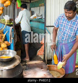 Square ritratto di un uomo vendere la pannocchia dal ciglio della strada in Sri Lanka. Foto Stock