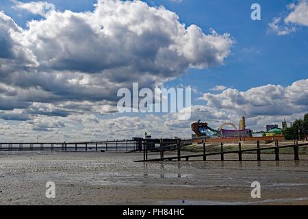 La cattura di enormi nuvole bianche raccolta su divertimenti e alla spiaggia di South End sul mare, in Essex. Foto Stock