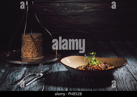 Composizione alimentare della candela, Forcella con coltello, soba con tofu e verdure decorate con semi germinati dei semi di girasole Foto Stock