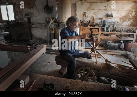 Un Menorcan falegname, o arader, fa una semplice ruota di legno nella sua bottega in Menorca, Spagna. Foto Stock