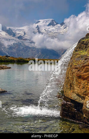 Piccolo lago con cascata, Estate a Hohe Saas per funivia sopra Saas Grund, Svizzera, alpi svizzere, Foto Stock