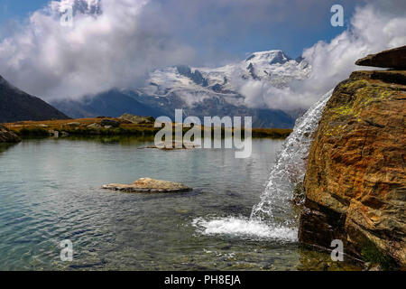 Piccolo lago con cascata, Estate a Hohe Saas per funivia sopra Saas Grund, Svizzera, alpi svizzere, Foto Stock