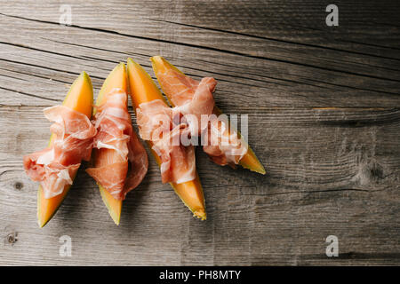 Spagnolo gustosi antipasti mediterranea Melone e prosciutto su vintage tavolo in legno. Primo piano. Orizzontale con copia spazio. Foto Stock