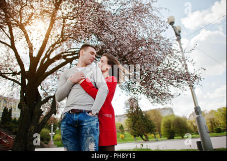 Abbracciando giovane in amore sfondo ciliegio fiore di sunbeam Foto Stock