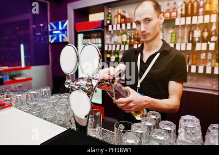 Il barista versa una birra al bar del club Foto Stock