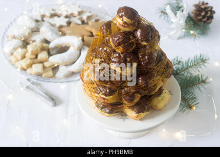 Crockembush torte e biscotti di Natale in una decorazione di Natale con una ghirlanda di rami di abete e coni. Messa a fuoco selettiva. Foto Stock