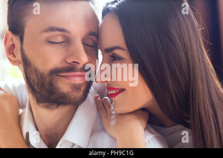 Coppia giovane avente romantica serata a casa la donna libro di lettura Foto Stock