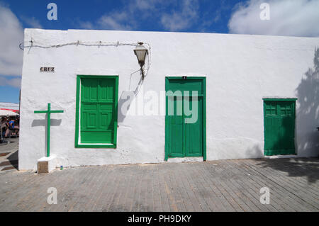 Vecchia chiesa con porte verdi su un muro bianco Foto Stock