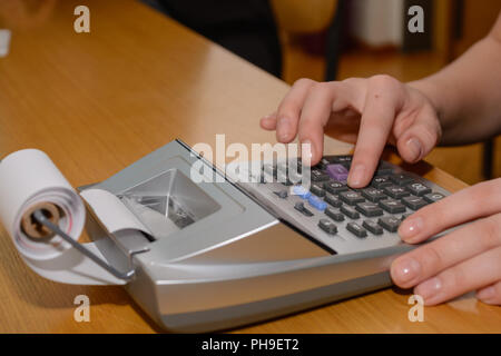 Lavoratore di ufficio aspetta con la stampa calcolatrice tascabile - close-up Foto Stock