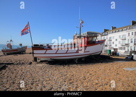 Barche da pesca sulla ripida spiaggia e il lungomare di trattare su alla costa del Kent Foto Stock