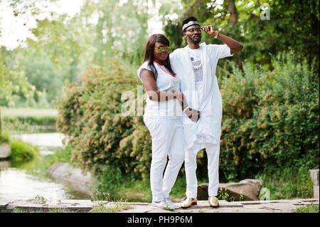 Africani ricchi di coppia al bianco vestito nazionale e occhiali da sole Foto Stock