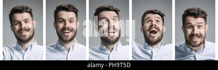 Set di giovane di ritratti con diverse emozioni felici su grigio di sfondo per studio Foto Stock