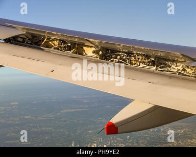 Aria sportellino del freno completamente aperto sull'ala di un aereo di linea per rallentare il velivolo per l'atterraggio. Foto Stock