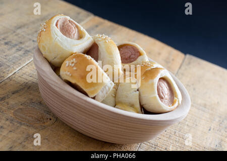 Salsicce laminati in croissant pasta cotta raffreddamento sulla rastrelliera metallica. Foto Stock