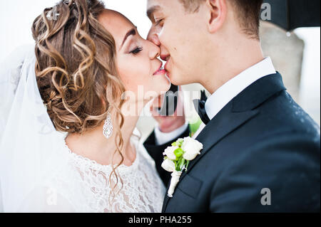 Close up ritratto di coppie in viaggio di nozze a pioggia sotto ombrellone Foto Stock