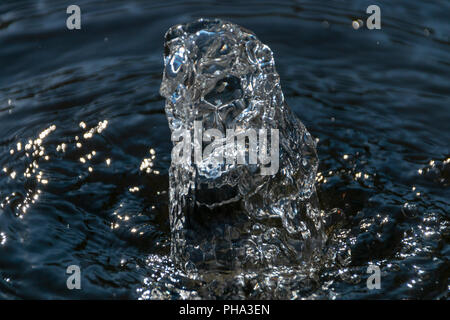 Una vista ravvicinata di acqua limpida che viene spinto fuori dalla parte superiore del calcestruzzo di una fontana di acqua Foto Stock