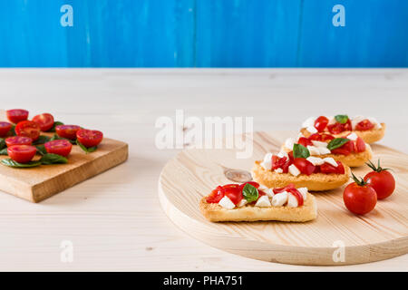 Italian crostini con mozzarella di bufala, pomodorini e basilico Foto Stock