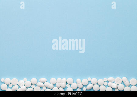 Bianco pillole mediche su sfondo blu Foto Stock