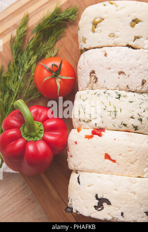 Varietà di casa fatta di formaggio e paprica e erbe su una tavola di legno. messi in salamoia cagliata di formaggio bianco con verdure. Foto Stock