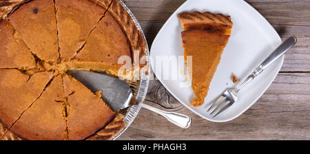 Fette di torta di zucca con spatola su tavola in legno rustico Foto Stock