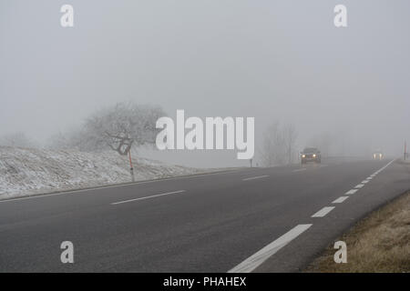 Il traffico su strada in caso di nebbia e fondo stradale sdrucciolevole Foto Stock