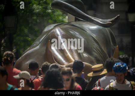 Orde di turisti cluster intorno e posare per le foto di fronte al Wall Street Bull, artista Arturo DiModica, su Broadway in Lower Manhattan a New York il giovedì 30 agosto, 2018. Il mercato azionario è avente la più lunga bull run nella storia, a partire dal 9 marzo 2009 come la grande recessione si è conclusa. (Â© Richard B. Levine) Foto Stock