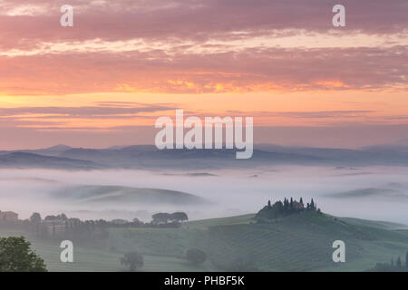 Podere Belvedere e la nebbia di sunrise, San Quirico d'Orcia, Val d'Orcia, Sito Patrimonio Mondiale dell'UNESCO, Toscana, Italia, Europa Foto Stock