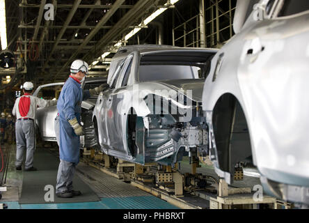 I lavoratori lavorano su un veicolo a motore Nissan Co.s impianto di assemblaggio in Tochigi, Giappone giovedì 12 nov. 2009. Fotografo: Robert Gilhooly Foto Stock