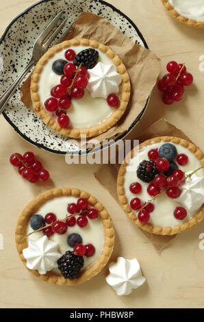 Piccolo tartlet con panna alla vaniglia Bacche e meringa Foto Stock