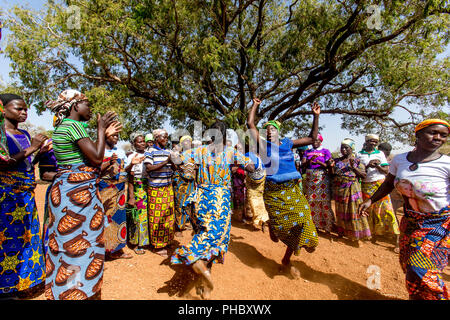 I membri di una donna cooperativa di microfinanza accoglie il visitatore con le danze nel nord del Togo, Africa occidentale, Africa Foto Stock