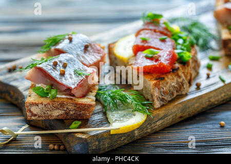 Toast con aringa, caviale e cipolla verde e aneto. Foto Stock