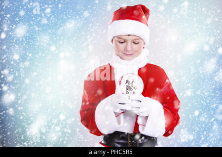 Ragazzo vestito come Santa nel paesaggio invernale Foto Stock