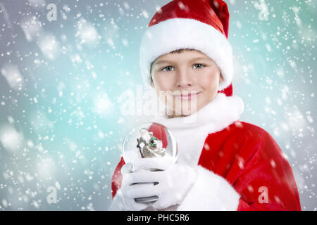 Ragazzo vestito come Santa nel paesaggio invernale Foto Stock